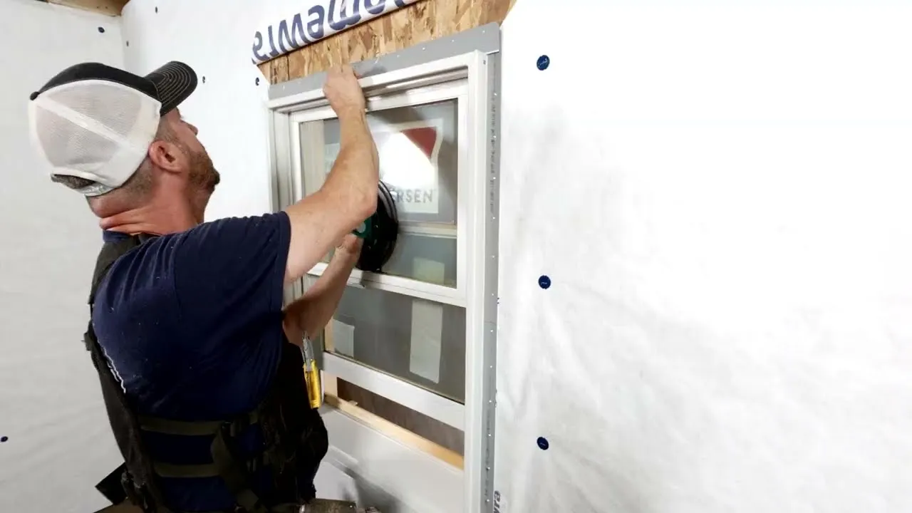 An installer pressing a new window into its rough opening